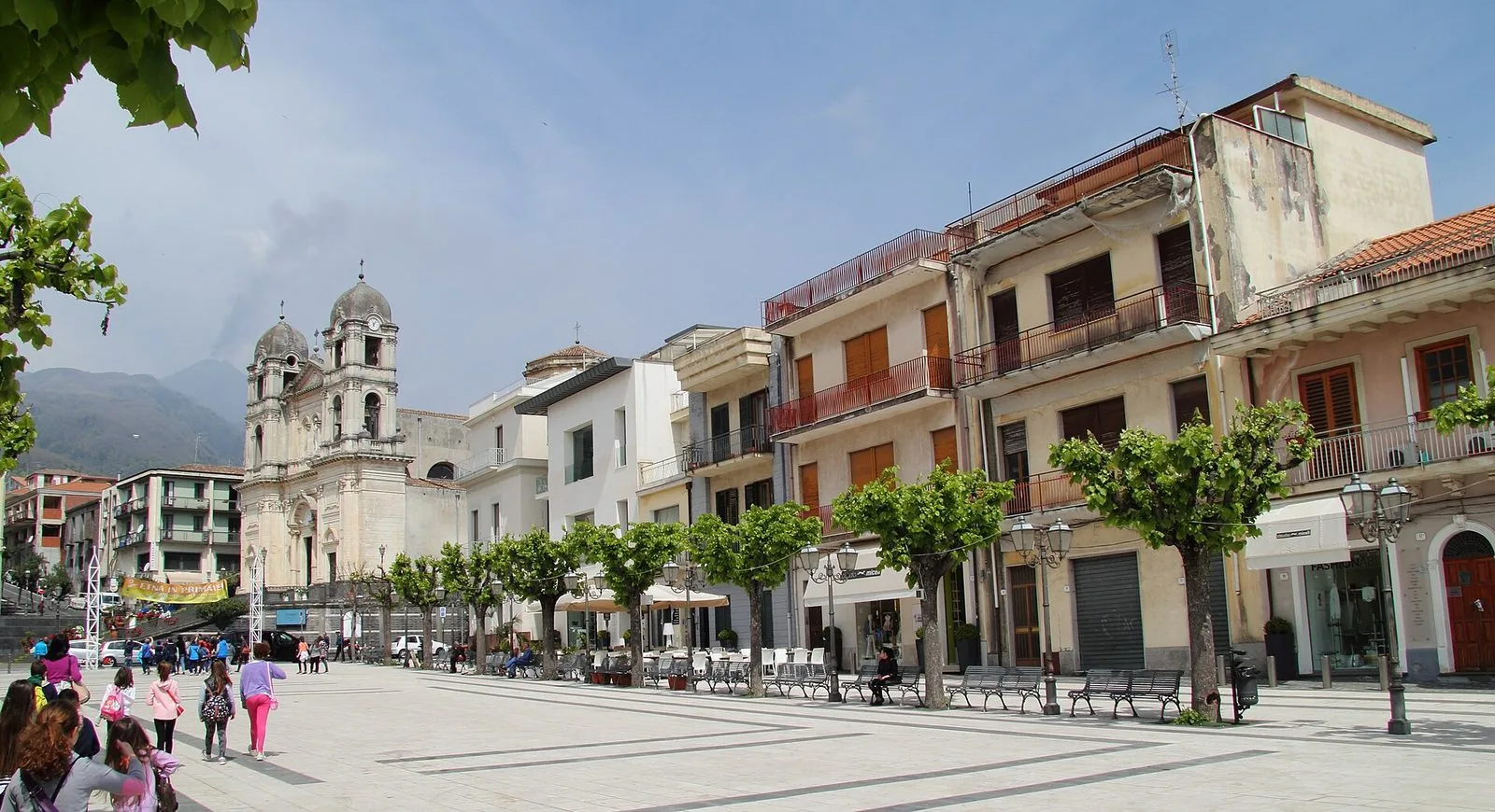 La piazza del centro di Zafferana Etnea con la facciata della Chiesa Madre e il profilo dell'Etna sullo sfondo